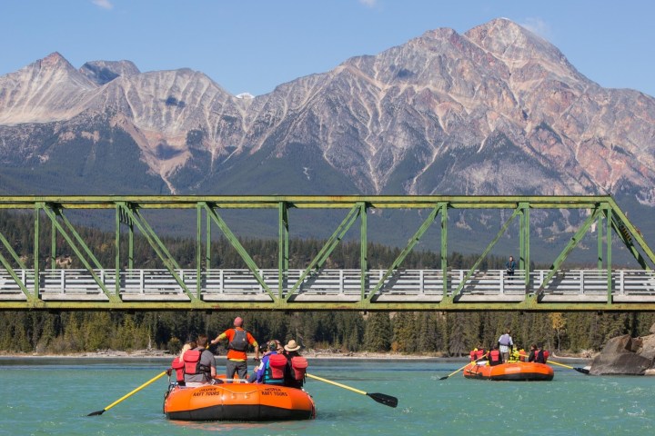 a group of people riding a raft on the Athabasca River in Jasper, Canada